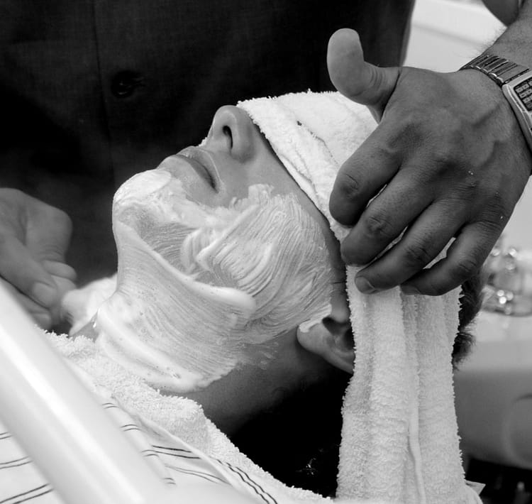 Man getting a barbershop shave being lathered with shave brush